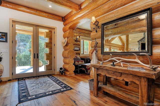 foyer entrance featuring french doors, log walls, wood-type flooring, and beam ceiling