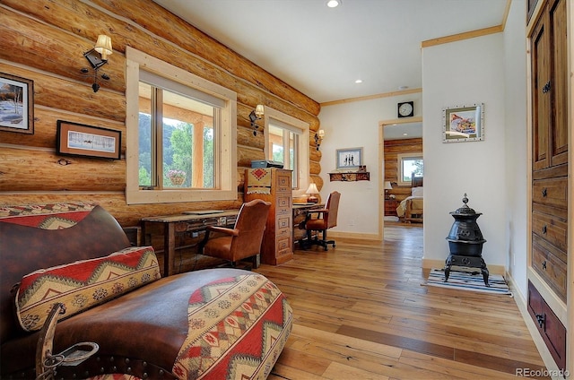 interior space with rustic walls, ornamental molding, and light hardwood / wood-style flooring