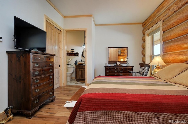 bedroom with crown molding, light hardwood / wood-style flooring, and connected bathroom