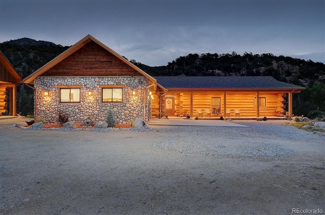 view of front of home featuring stone siding and log siding