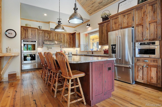 kitchen featuring light wood-style flooring, a warming drawer, appliances with stainless steel finishes, tasteful backsplash, and ornamental molding