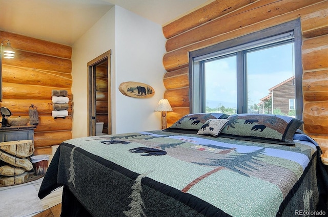 bedroom featuring log walls and wood finished floors