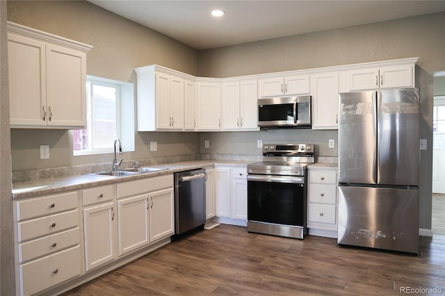 kitchen featuring stainless steel appliances, light countertops, white cabinets, and a sink