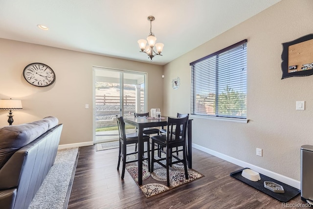 dining space featuring dark wood-type flooring and a notable chandelier