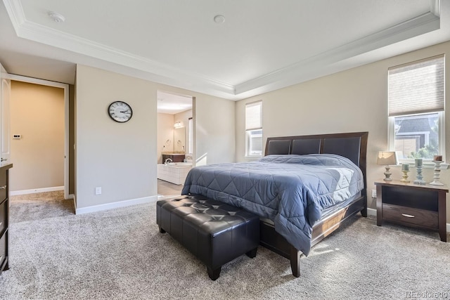 bedroom with carpet flooring, a tray ceiling, connected bathroom, and crown molding