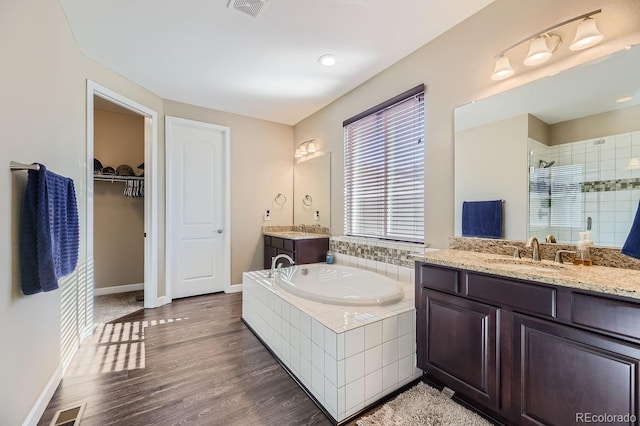 bathroom featuring vanity, independent shower and bath, and hardwood / wood-style floors