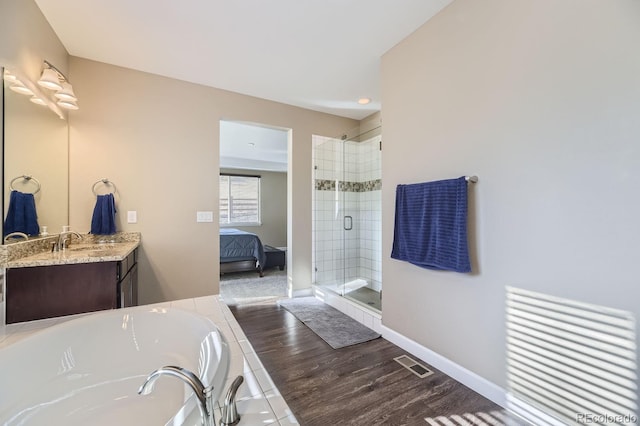 bathroom featuring vanity, hardwood / wood-style floors, and independent shower and bath