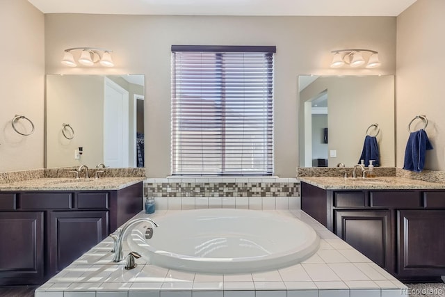 bathroom featuring vanity and a relaxing tiled tub