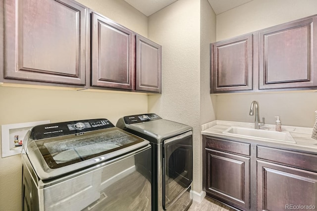 laundry room with cabinets, sink, and separate washer and dryer