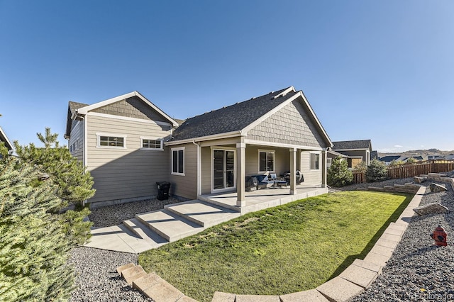 rear view of property featuring a patio and a lawn