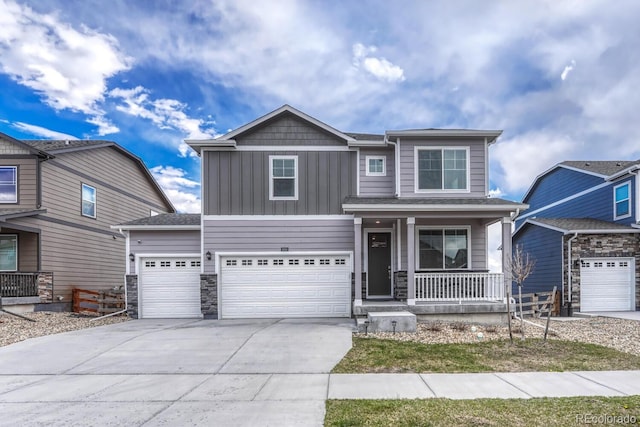 5053 Janga Dr, Colorado Springs, CO 80924 - view of front of home featuring covered porch, driveway, board and batten siding, stone siding, and an attached garage