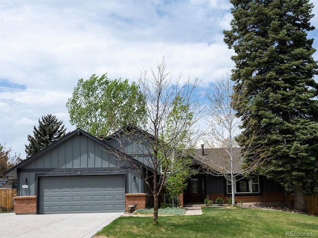 view of front of home featuring board and batten siding, brick siding, fence, and a front yard