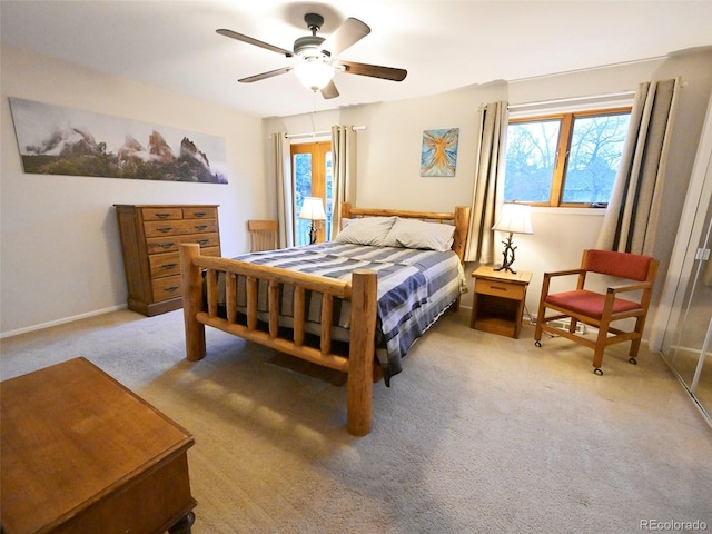 bedroom featuring baseboards, multiple windows, carpet flooring, and ceiling fan