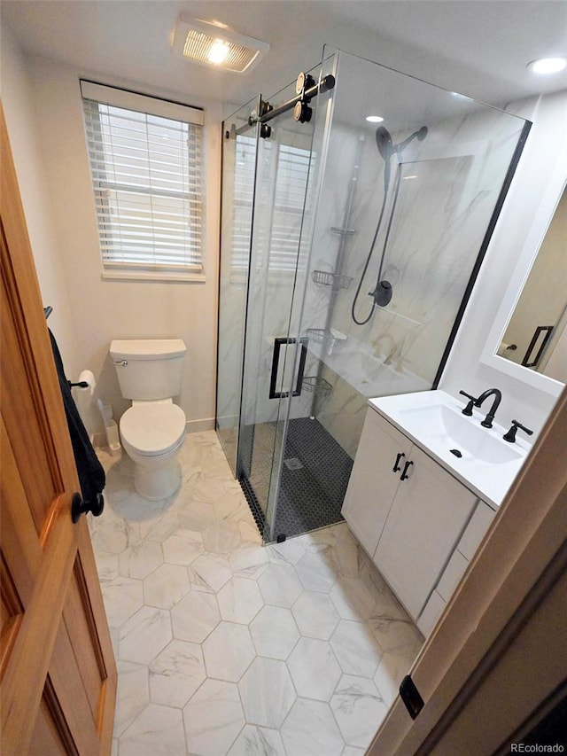 bathroom with toilet, a marble finish shower, tile patterned flooring, and vanity