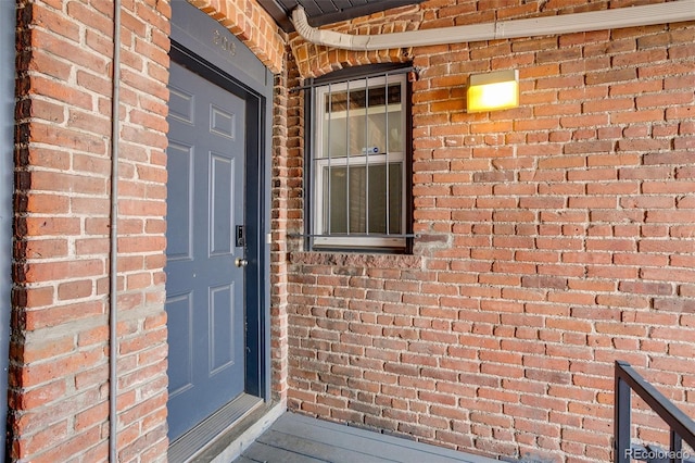 entrance to property featuring brick siding