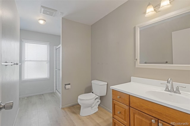 full bath with toilet, wood finished floors, a shower with shower door, and vanity