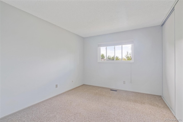 empty room featuring carpet flooring and a textured ceiling