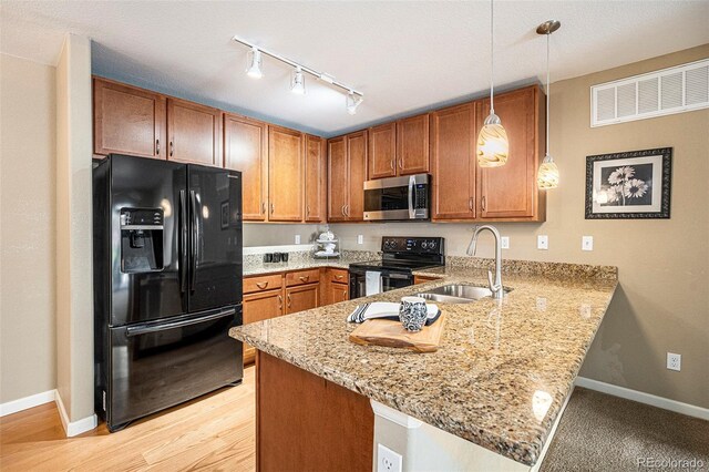 1144 Rockhurst Dr Unit 105, Highlands Ranch, CO 80129 - kitchen with black appliances, a sink, a peninsula, track lighting, and brown cabinetry