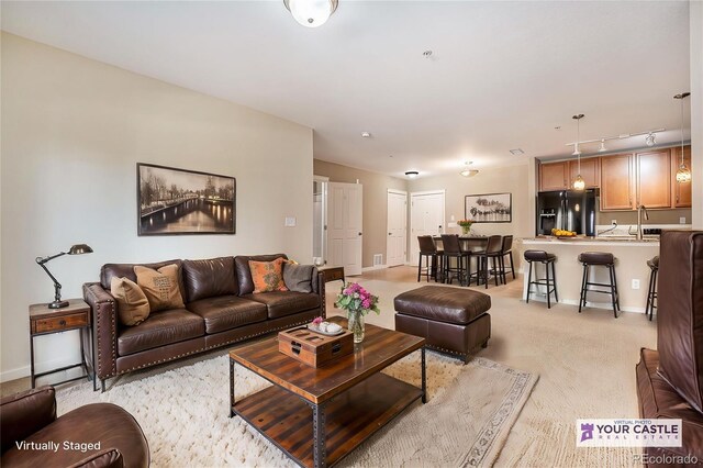 1144 Rockhurst Dr Unit 105, Highlands Ranch, CO 80129 - living room with rail lighting, light carpet, and baseboards