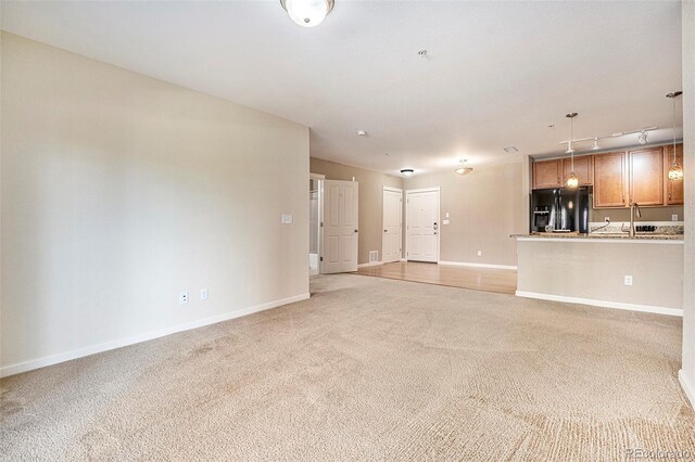 1144 Rockhurst Dr Unit 105, Highlands Ranch, CO 80129 - unfurnished living room with track lighting, light colored carpet, and baseboards