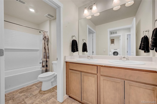 full bathroom with vanity, washer / dryer, shower / tub combo, and toilet