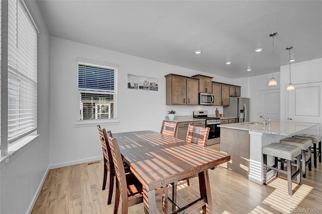 dining area featuring sink and light hardwood / wood-style floors