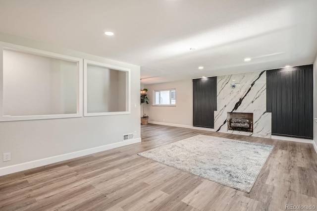 basement with a wood stove and light wood-type flooring