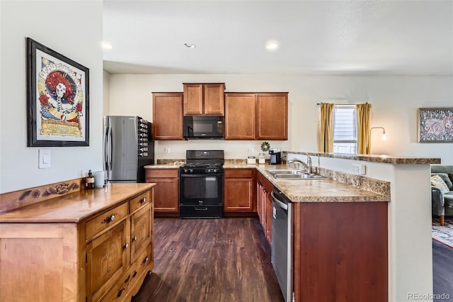 kitchen with brown cabinetry, a peninsula, dark wood-style floors, black appliances, and a sink