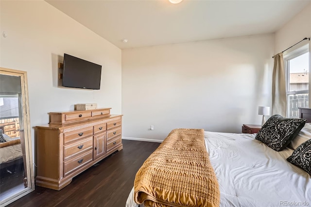 bedroom with dark wood finished floors and baseboards