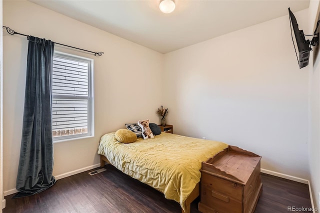 bedroom featuring visible vents, baseboards, and wood finished floors