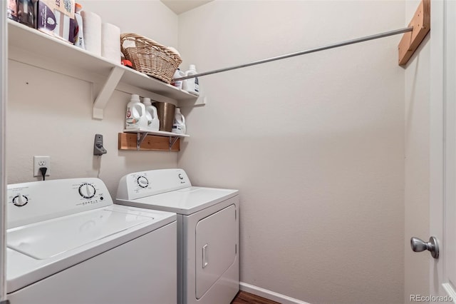 clothes washing area with laundry area, washing machine and dryer, and baseboards