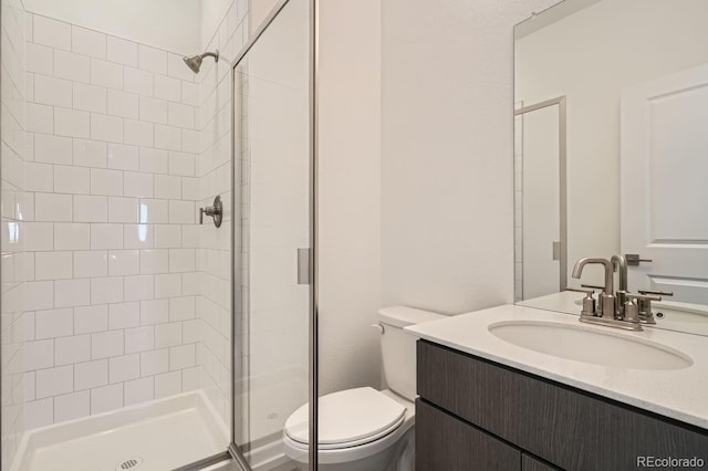 bathroom featuring vanity, toilet, and a shower with shower door