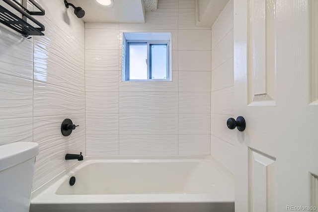 bathroom with tiled shower / bath combo and toilet