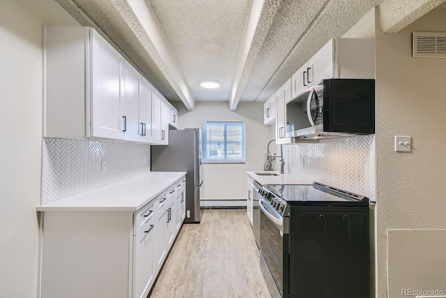 kitchen featuring appliances with stainless steel finishes, light countertops, white cabinetry, and visible vents