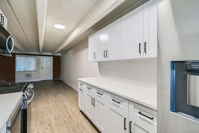 kitchen featuring light countertops, light wood-style floors, white cabinetry, and stainless steel appliances