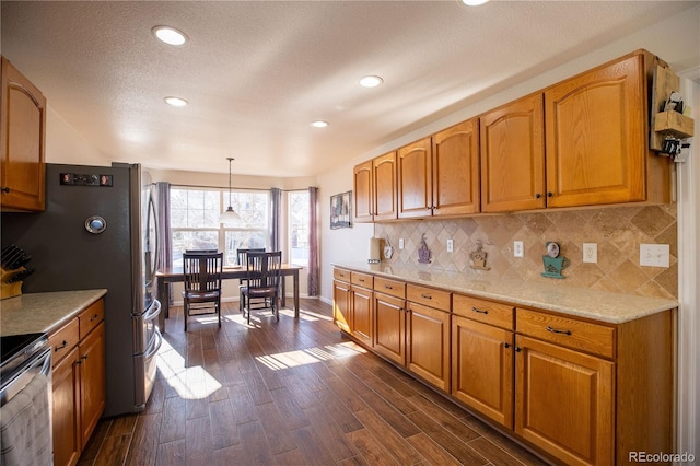 kitchen featuring dark wood-style floors, pendant lighting, brown cabinets, backsplash, and baseboards