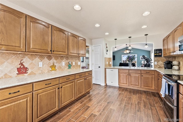 1128 S Duquesne Cir, Aurora, CO 80018 - kitchen featuring double oven range, dishwasher, recessed lighting, brown cabinets, and vaulted ceiling