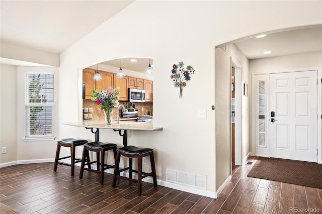 1128 S Duquesne Cir, Aurora, CO 80018 - entryway featuring dark wood-style flooring, baseboards, arched walkways, and recessed lighting