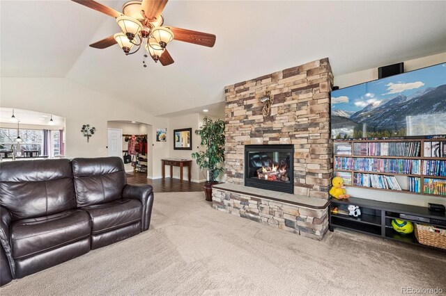 1128 S Duquesne Cir, Aurora, CO 80018 - living area featuring ceiling fan, lofted ceiling, arched walkways, a fireplace, and carpet flooring