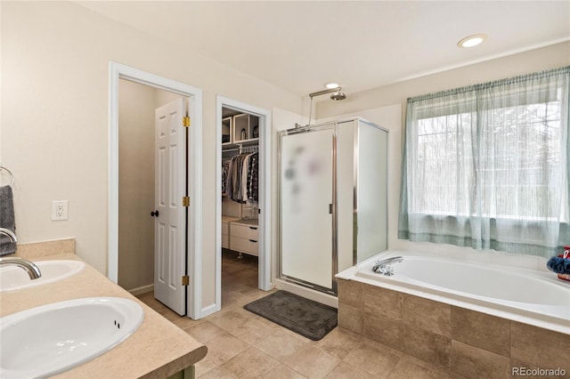 1128 S Duquesne Cir, Aurora, CO 80018 - bathroom featuring a stall shower, a walk in closet, a garden tub, and double vanity