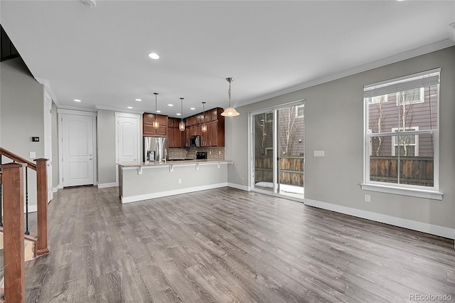 unfurnished living room with dark wood-style floors, crown molding, stairway, and baseboards