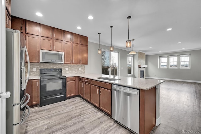 kitchen featuring stainless steel appliances, a peninsula, a sink, backsplash, and light stone countertops