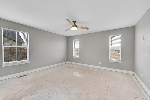 unfurnished room featuring baseboards, visible vents, ceiling fan, and concrete flooring