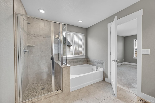 full bath featuring a bath, a shower stall, baseboards, and tile patterned flooring