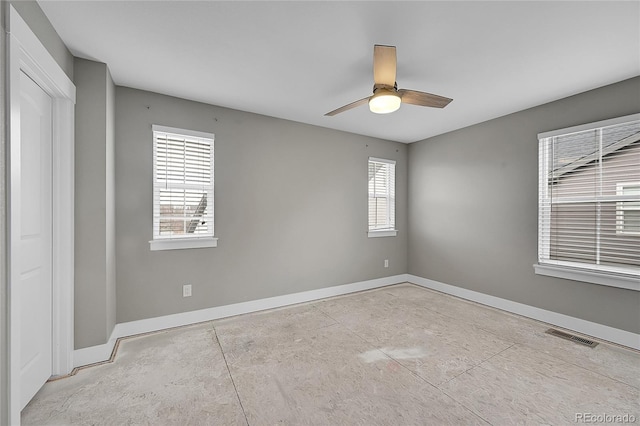 spare room with visible vents, a ceiling fan, and baseboards