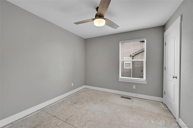 empty room featuring ceiling fan, visible vents, and baseboards