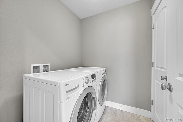 laundry area with laundry area, washer and clothes dryer, and baseboards