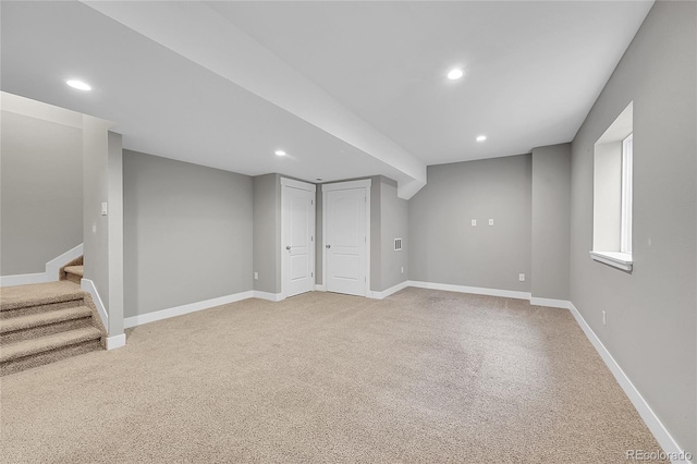 below grade area with baseboards, stairway, light colored carpet, and recessed lighting