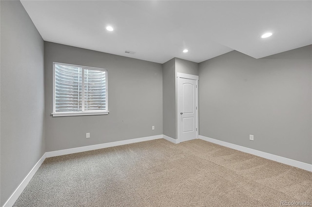 spare room with light carpet, recessed lighting, visible vents, and baseboards