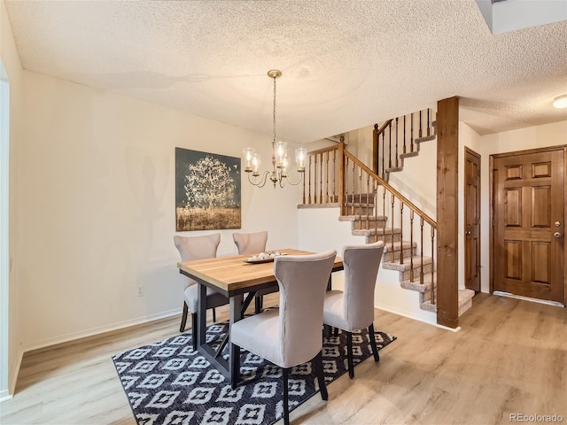 dining area featuring hardwood / wood-style flooring, a notable chandelier, and a textured ceiling